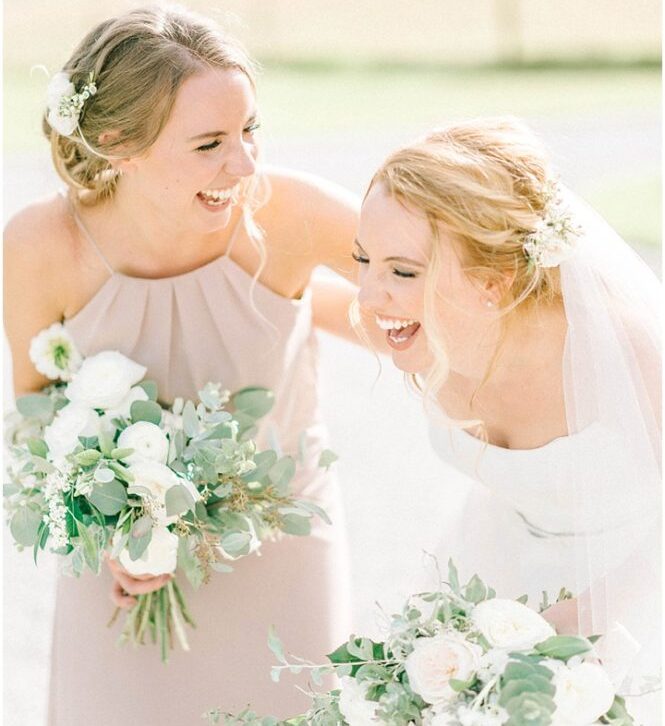 bride and her sister bridesmaid laughing