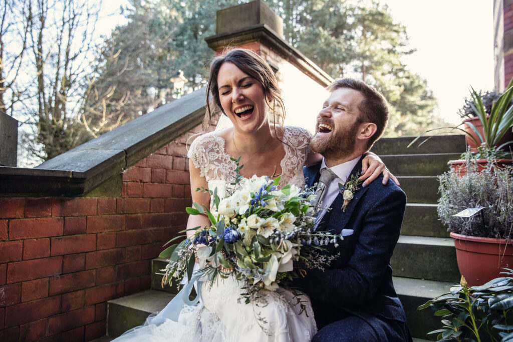 Bride and groom laughing while sat on the steps of the pumping house Nottingham