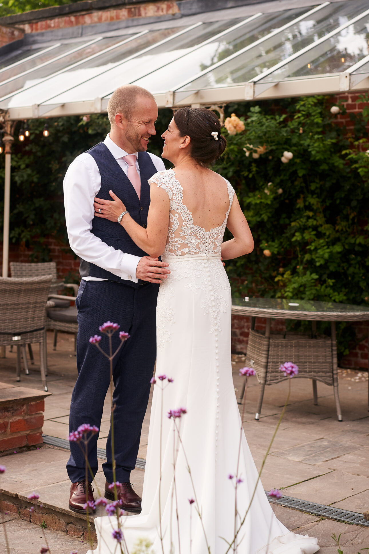 Bride and Groom on their wedding day at The walled |Garden Nottingham showing the brides elegant low bun with delicate hair accessory.