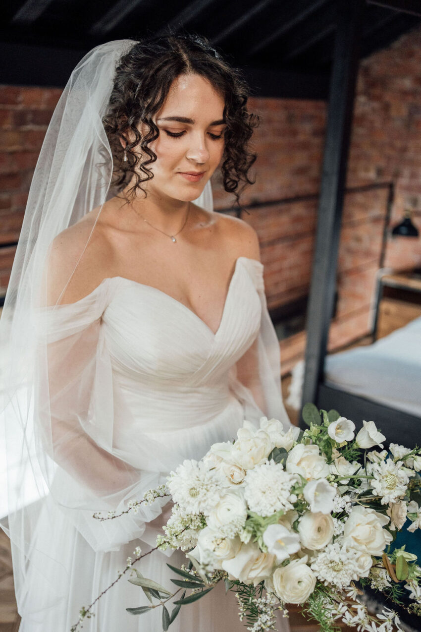 Bride with romantic curly bridal updo, face framing curls and wedding veil at The Pumping House Ollerton