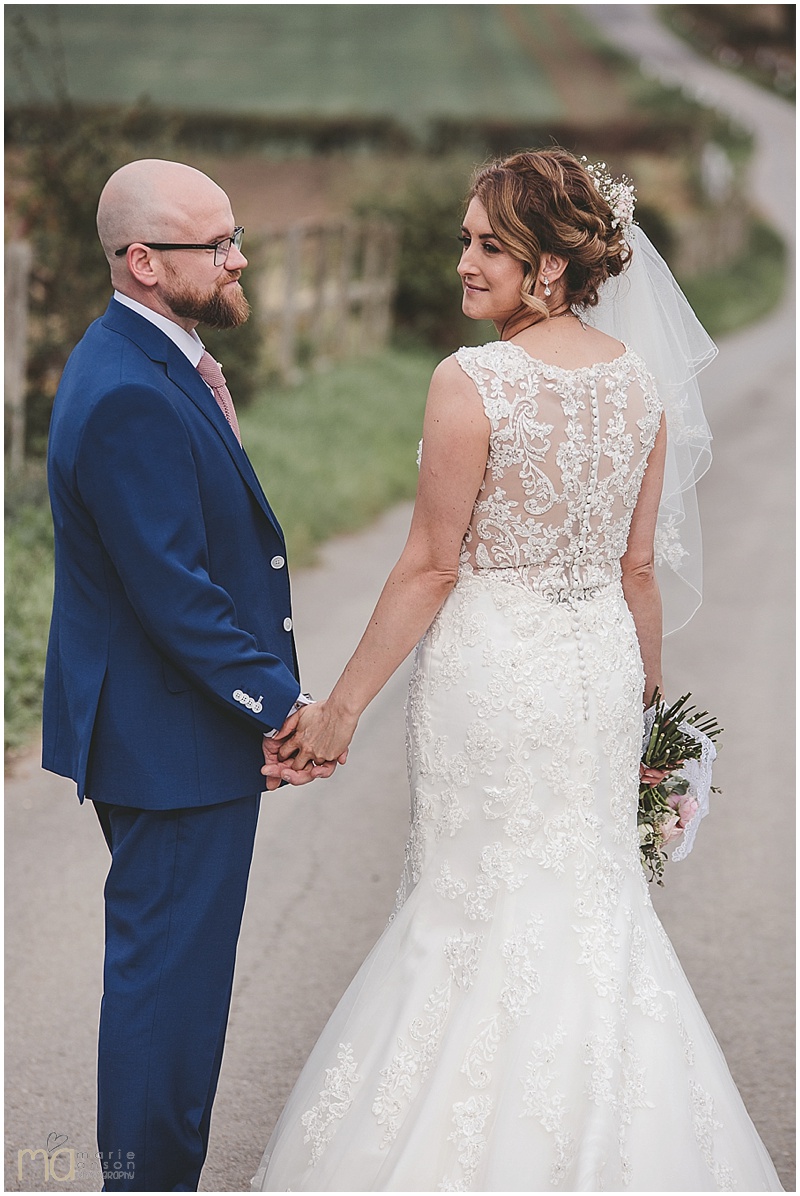 Bride with elegant textured bridal updo with her husband on her wedding day at Swancar Farm